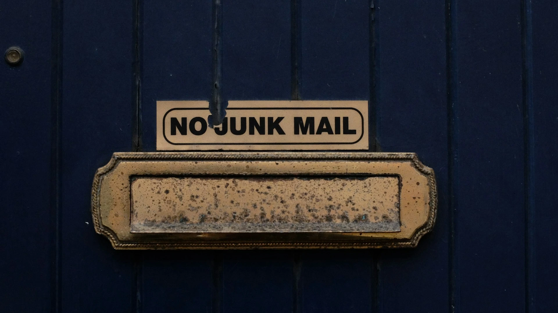 A no junk mail box on a blue door